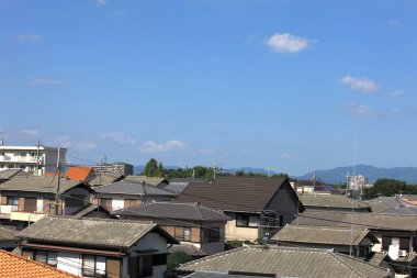 Açık mavi gökyüzünün altındaki evlerin çatıları