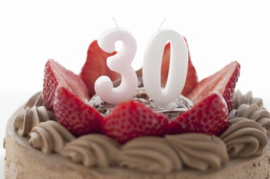Çilekli çikolatalı pasta üzerine otuz numara mum. 