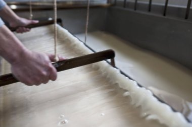 Ahşap çerçeve kullanarak geleneksel kağıt yapan eller