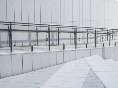 Geometrik çizgiler ve metal korkulukların yer aldığı modern bir yapı.