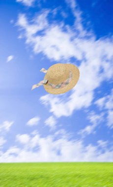 Mavi gökyüzünde uçan bir hasır şapka 