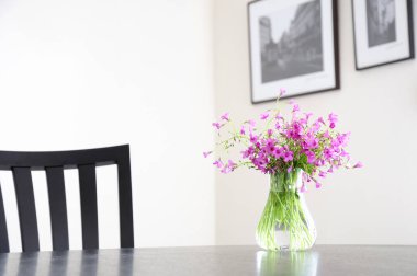 Güzel pembe çiçekler cam vazoda, rahat oturma odasında.