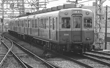 Japon demiryollarından geçen siyah beyaz tren görüntüsü.