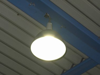 Metal kirişlerin altında asılı parlak endüstriyel tavan lambası