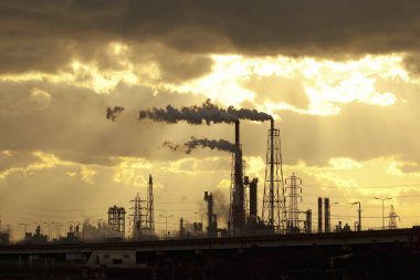 Gün batımına karşı boruları olan endüstriyel fabrika       