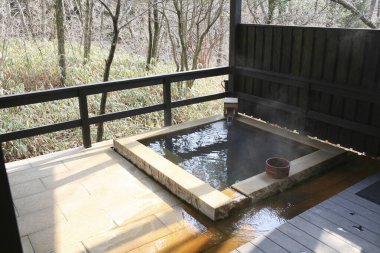 Oita, Kyushu, Japonya 'da bulunan lüks bir ryokan olan Kai Aso' da açık hava özel onsen (sıcak bahar banyosu).