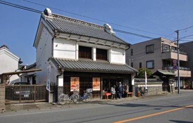 Beyaz duvarlı geleneksel Japon binası çatısı güneşli sokak manzarası