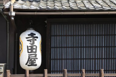 Geleneksel Japon kağıt feneri ahşap binanın dışında asılı.