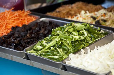 Metal tepsilerde taze kesilmiş sebzeler.