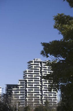 Modern apartman binaları açık mavi gökyüzüne karşı yükseliyor