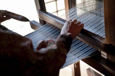 Atölyedeki geleneksel dokuma tezgahında el dokuması.