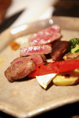 Dilimlenmiş biftek ve sebze tabağı.