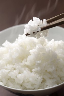 Haşlanmış pirinç ve yemek çubuklarının yakın plan görüntüsü. 