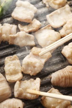 Et parçalarını ızgarada çeviriyor yemek çubukları, lezzetli barbekü çubukları kullanıyor.