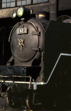 Arka plandaki tren istasyonunda buharlı lokomotif