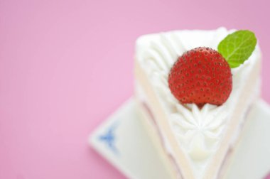 Kırmızı çilekle süslenmiş lezzetli kremalı pasta.