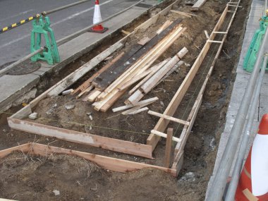 Kısmen inşa edilmiş kaldırım siperlerine saçılmış tahta kalaslar.