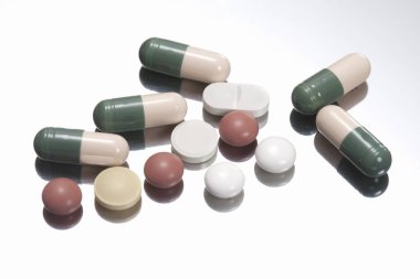 Beyaz arkaplanda hapların ve kapsüllerin yakın plan görüntüsü     