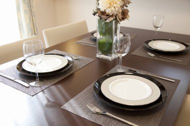 Cam vazoda çiçekli kahverengi masanın üzerinde zarif bir masa.