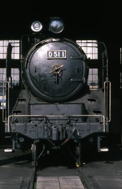 Arka plandaki tren istasyonunda buharlı lokomotif