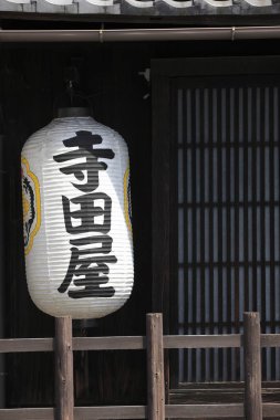 Geleneksel ahşap binanın dışında asılı büyük Japon kağıt feneri.