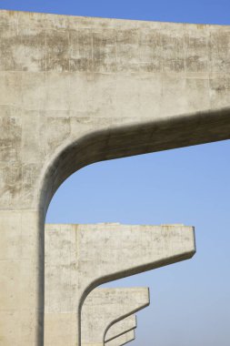 Otoyol inşaatı, mavi gökyüzüne karşı beton köprü desteği