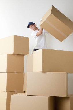 Genç Asyalı kurye kutuları topluyor.