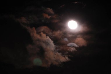 Gece gökyüzünde bulutlarla ay ışığı