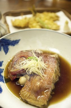 Soslu zencefille süslenmiş balık buğulama.