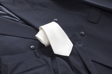 Siyah erkek takım elbisesine beyaz kravat tak.