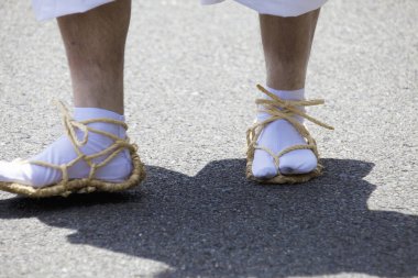 Eşsiz sandaletleri ve beyaz çorapları vardı.