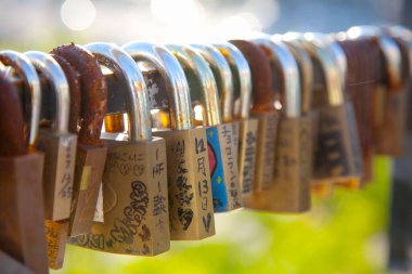 Şehrin arka planında, çitin üzerinde bir sürü aşk kilidi var.