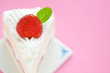 Kırmızı çilekle süslenmiş lezzetli kremalı pasta.