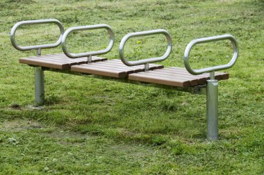 Güneşli bir günde parkta ahşap bir bank.