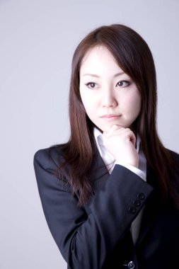 Genç ve güzel Asyalı bir kadının açık arkaplandaki yakın çekimi.