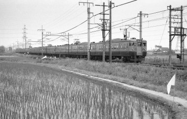 Tren raylarında giden bir trenin siyah beyaz fotoğrafı..