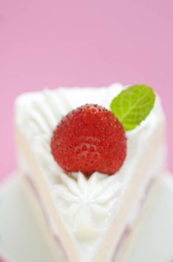 Kırmızı çilekle süslenmiş lezzetli kremalı pasta.