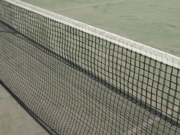 Güneşli bir günde ağlı ve gölgeli tenis kortu      