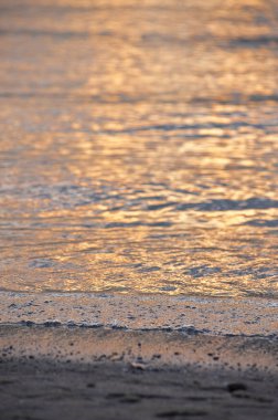 Gün batımında sahildeki deniz dalgalarının güzel manzarası.         