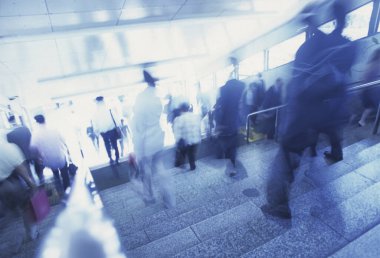 Şehirde merdivenlerden inip çıkan kalabalığın hareketli görüntüsü bulanık