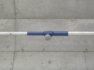 Duvara bağlı metal boru mavi ve gümüş renkler