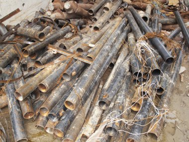 Paslı metal borular dışarıdaki karmaşık kabloların arasına saçılmış.