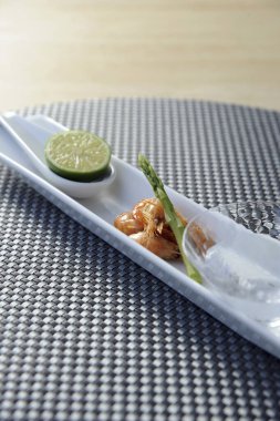 Dilimlenmiş limon diliminin yanında duran garnitürlü meze.