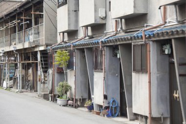 Sessiz cadde boyunca bitkilerle dolu küçük binalar.