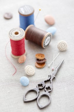 Gri kumaş arkaplanındaki dikiş aksesuarlarının yakın plan görüntüsü