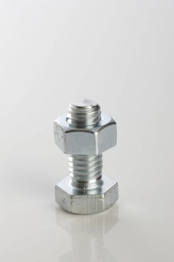 Beyaz stüdyo arka planında metal cıvata ve fındık