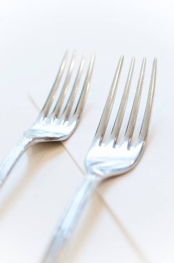 Beyaz arkaplanda iki gümüş çatal