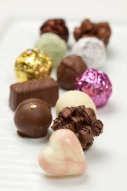 Beyaz arka planda lezzetli çikolata şekerlerinin yakın plan görüntüsü     