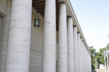 Dış bina girişini kaplayan uzun beyaz taş sütunlar