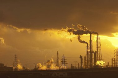 Gün batımına karşı boruları olan endüstriyel fabrika       